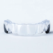Transparent plastic dental aligner on a plain background